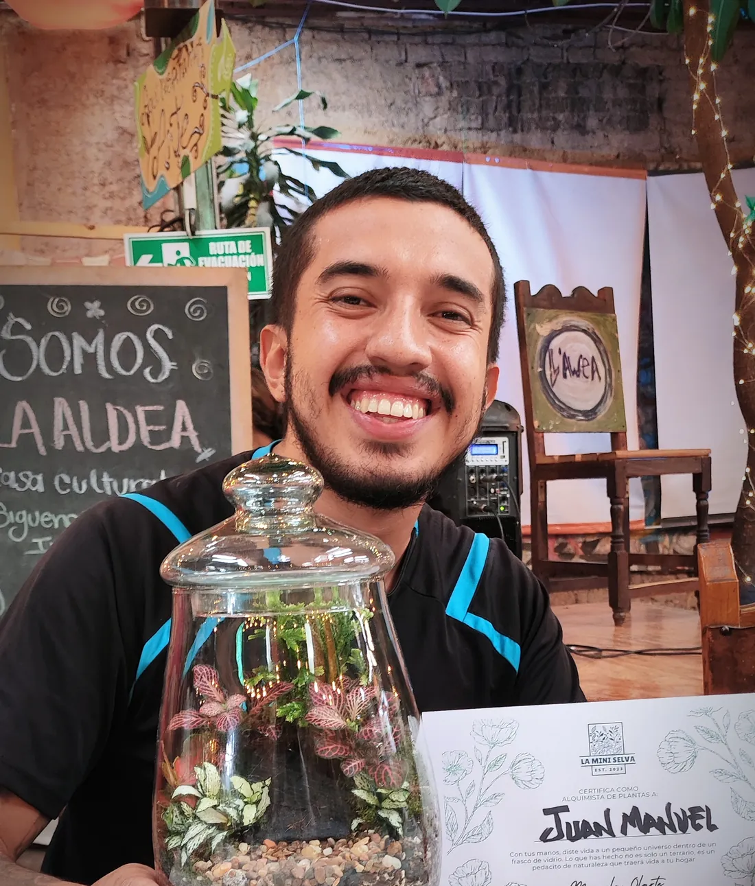 Cliente sonriendo con su terrario recién armado y su certificado de La Mini Selva