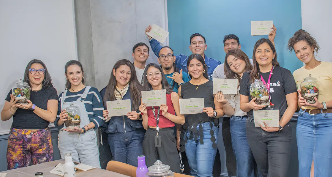 Grupo de personas sosteniendo sus certificados junto a los terrarios que armaron